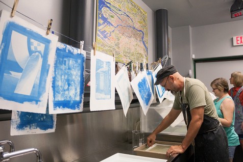 BK Skaggs, Shari Trennert, and Maylee Noah rinse their prints while others hang to dry. These prints show the first pass with the cyan layer.